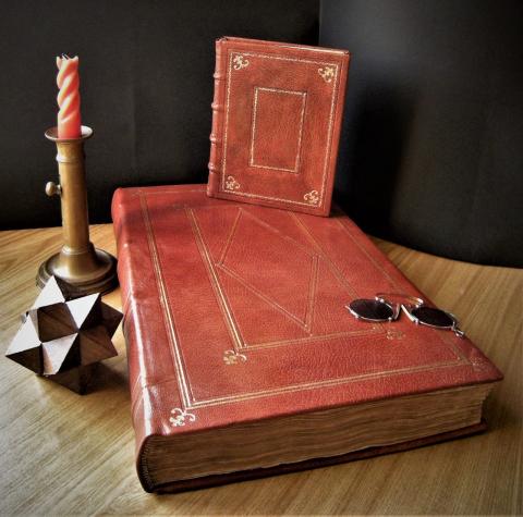 libro antico con copertina in pelle rossa e candelabro