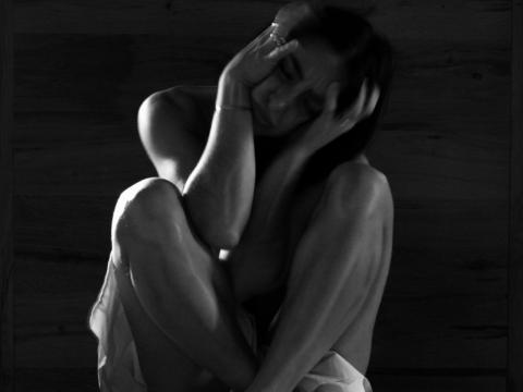 giovane donna accovacciata con la testa tra le mani